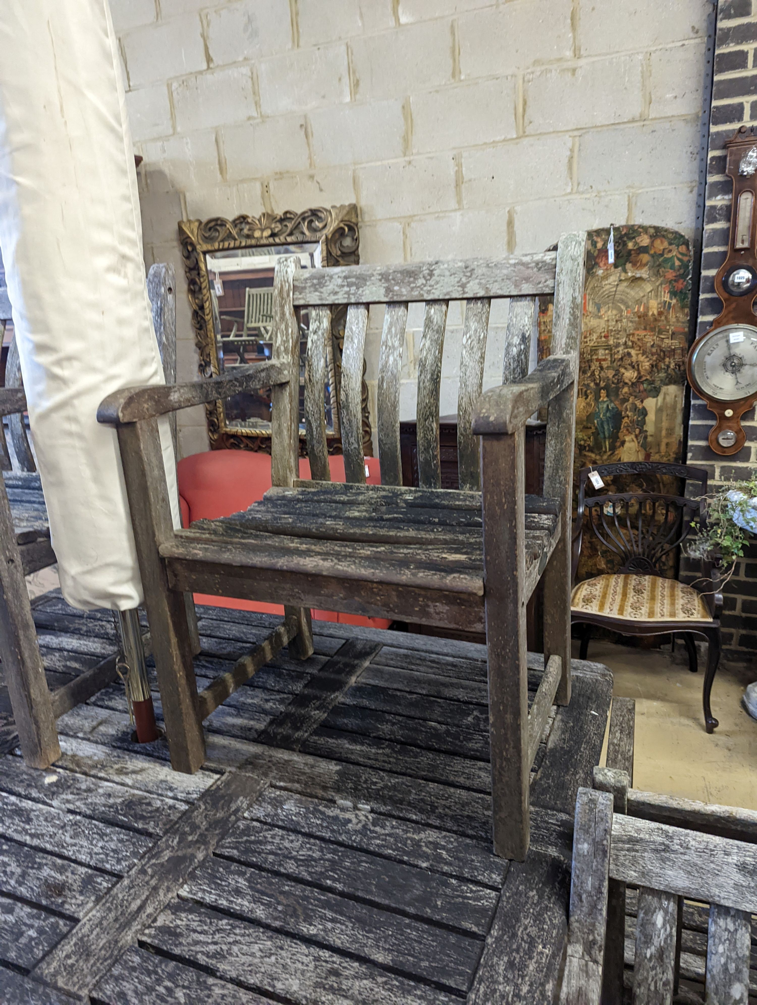 A rectangular weathered teak garden table, length 160cm, depth 110cm, height 73cm, six elbow chairs and a parasol